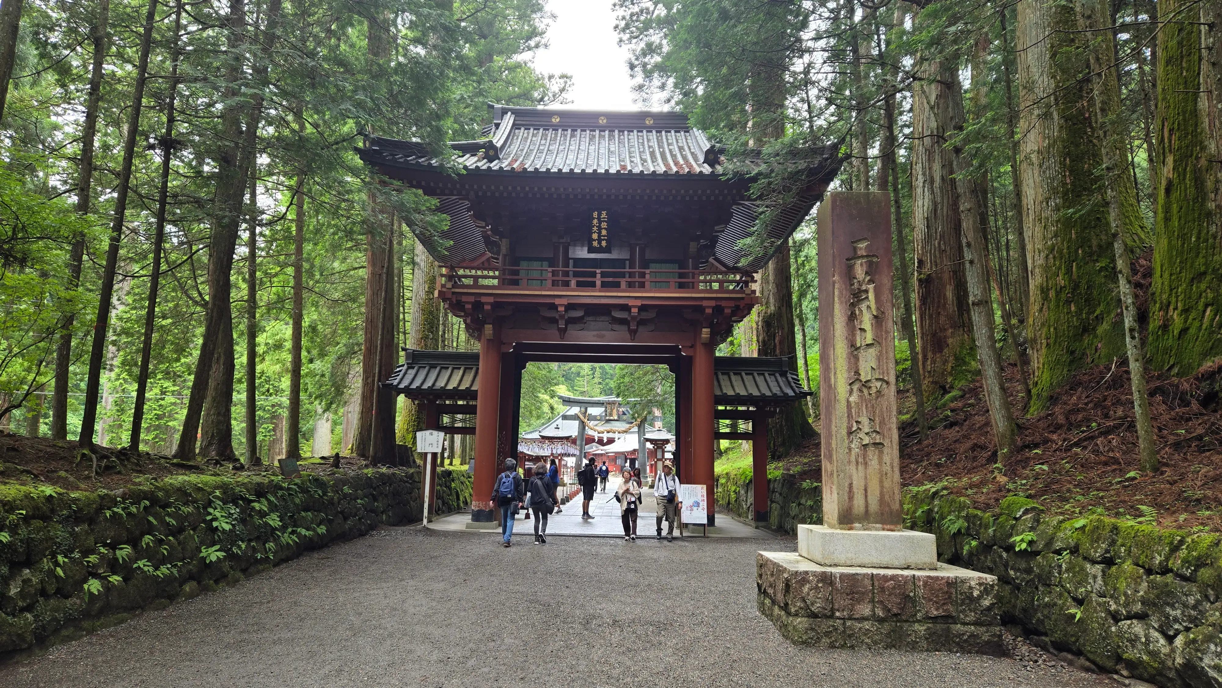 二荒山神社的樓門與刻著社名的石柱，以及銅瓦屋頂的拜殿。
