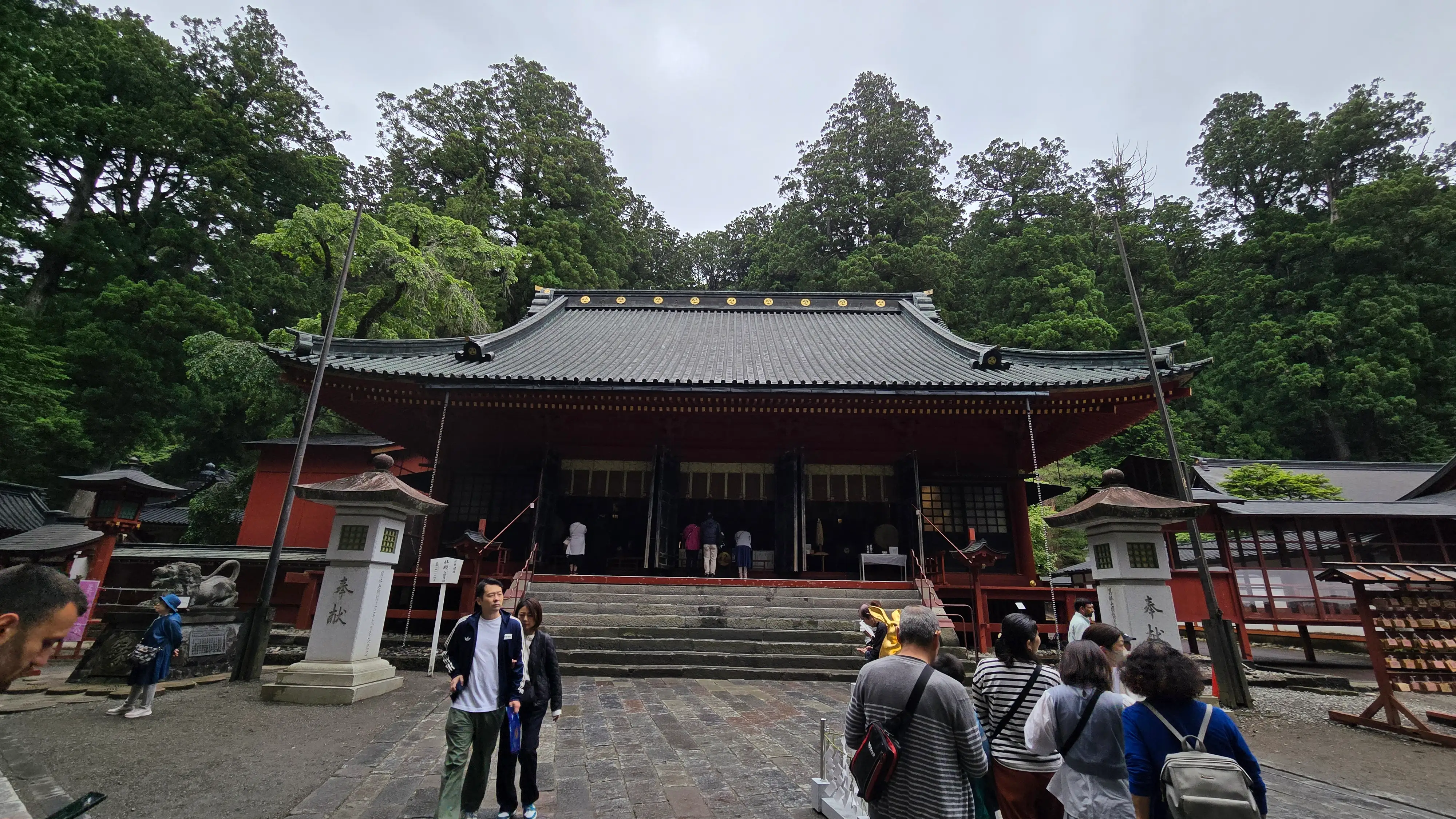 二荒山神社的樓門與刻著社名的石柱，以及銅瓦屋頂的拜殿。