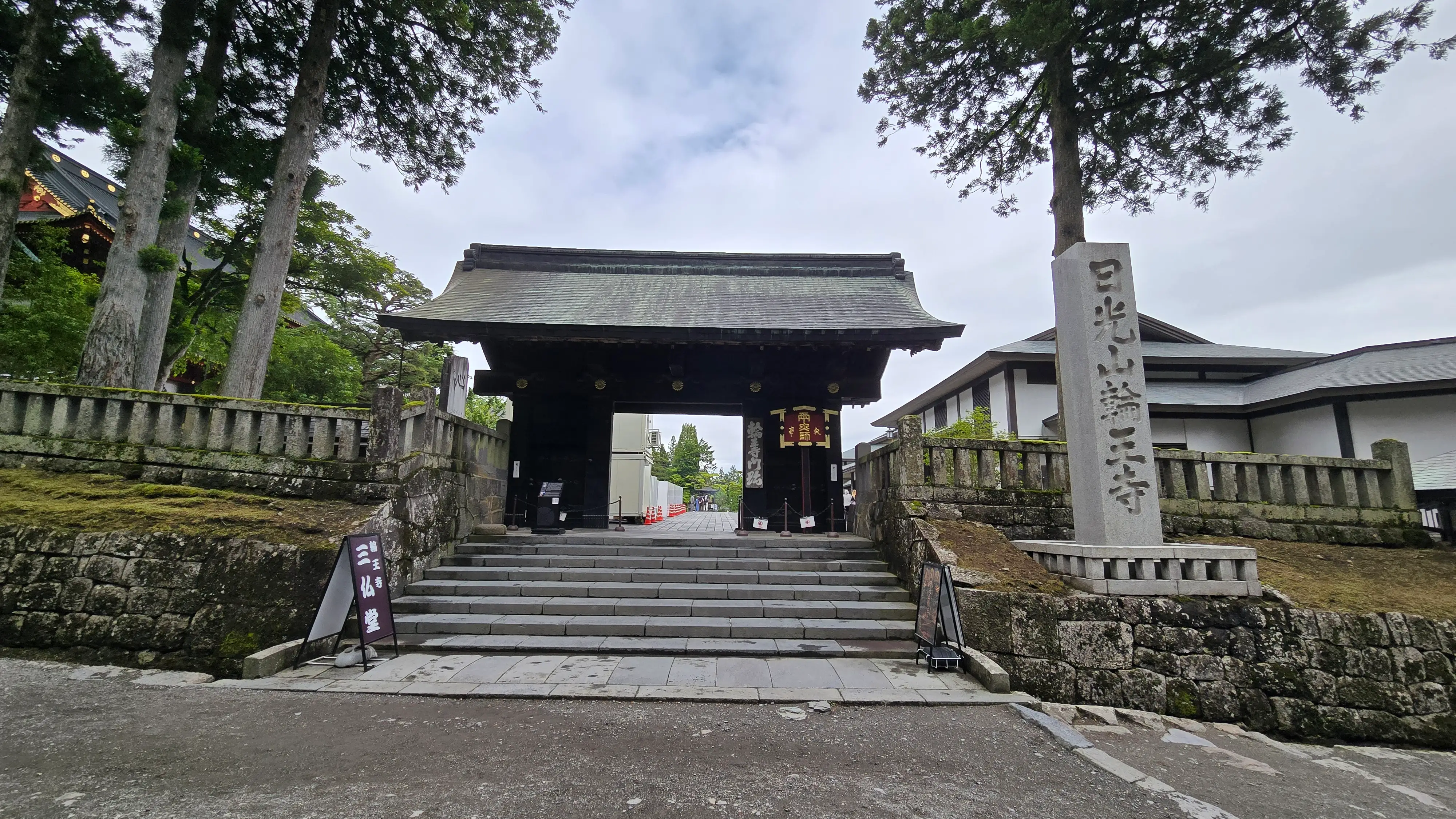 輪王寺的黑門，石階通往門內，一旁立著「日光山輪王寺」的石柱。